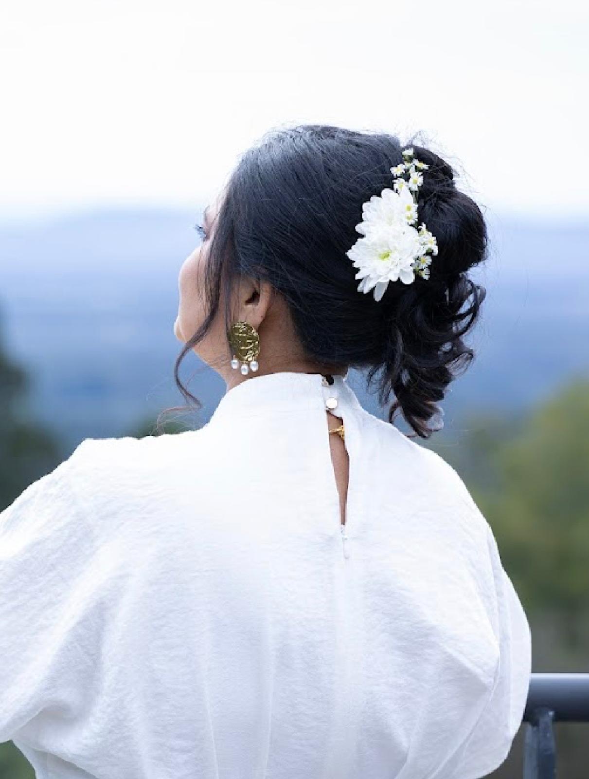 Bridal updo dressed with fresh flowers by the Natural Shine styling team