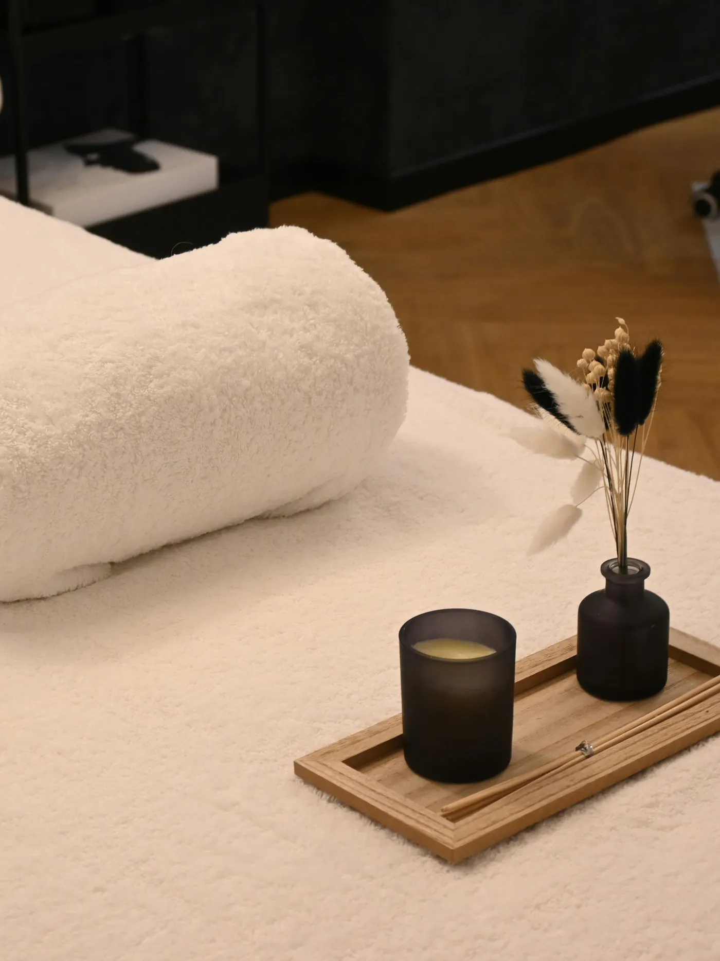 Folded towels and a lit candle in the treatment room at Natural Shine Hair & Beauty, North Kellyville